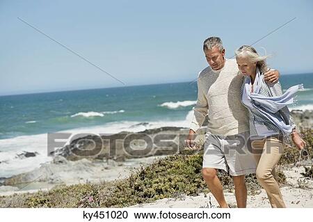 Stock Image - Couple walking on the beach. Fotosearch