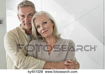 Stock Photo - Man hugging his wife from behind. Fotosearch