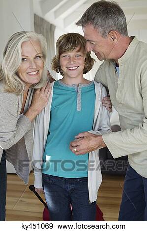 Stock Photo - Portrait of a boy with his grandparents at home. Fotosearch