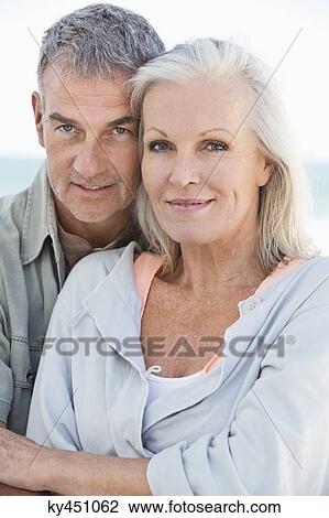 Stock Image - Portrait of a couple smiling on the beach. Fotosearch