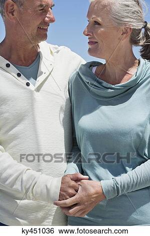 Stock Photograph - Senior couple smiling at each other. Fotosearch
