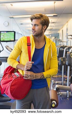 Man carrying a bag in a gym View Large Photo Image Stock Image - Man carrying a bag in a gym. Fotosearch