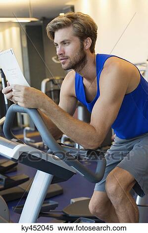 Man exercising on a machine in a gym View Large Photo Image Stock Photography - Man exercising on a machine in a gym. Fotosearch