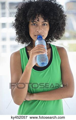Portrait of a woman drinking water from a bottle View Large Photo Image Stock Photo - Portrait of a woman drinking water from a bottle. Fotosearch