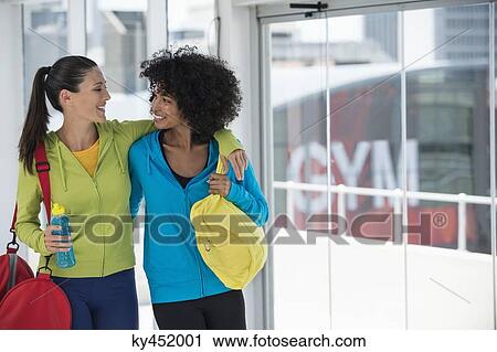 Two happy female friends carrying gym bags View Large Photo Image Stock Image - Two happy female friends carrying gym bags. Fotosearch