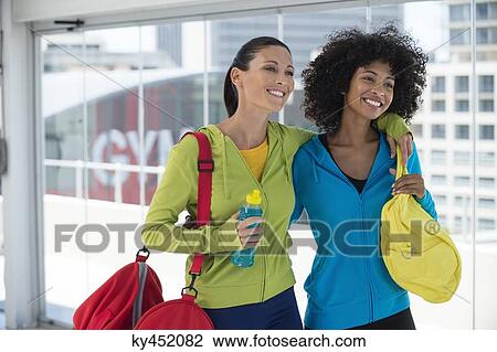Two happy female friends carrying gym bags View Large Photo Image Stock Image - Two happy female friends carrying gym bags. Fotosearch