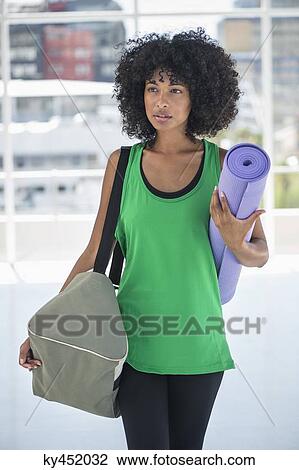 Woman carrying an exercise mat and a bag View Large Photo Image Stock Image - Woman carrying an exercise mat and a bag. Fotosearch