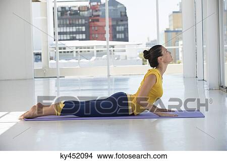 Woman exercising on exercise mat in a gym View Large Photo Image Picture - Woman exercising on exercise mat in a gym. Fotosearch