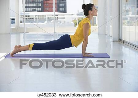 Stock Image - Woman exercising on exercise mat in a gym. Fotosearch