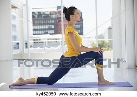 Stock Image - Woman exercising on exercise mat in a gym. Fotosearch