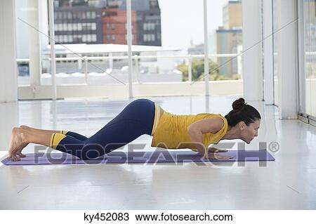 Woman exercising on exercise mat in a gym View Large Photo Image Stock Image - Woman exercising on exercise mat in a gym. Fotosearch