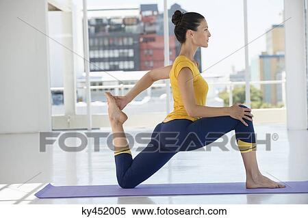 Stock Photography - Woman exercising on exercise mat in a gym. Fotosearch