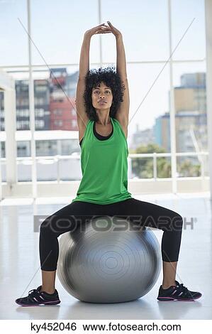 Stock Photograph - Woman exercising with a fitness ball. Fotosearch