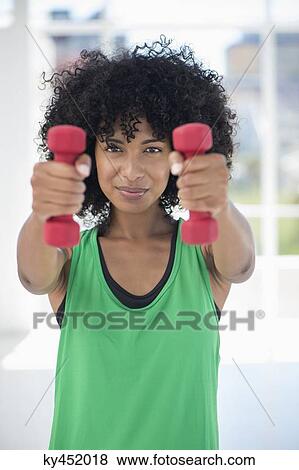 Woman exercising with dumbbells View Large Photo Image Stock Photo - Woman exercising with dumbbells. Fotosearch