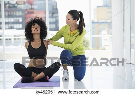 Woman exercising with her instructor in a gym View Large Photo Image Stock Image - Woman exercising with her instructor in a gym. Fotosearch