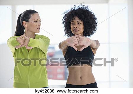 Woman exercising with her instructor in a gym View Large Photo Image Stock Photo - Woman exercising with her instructor in a gym. Fotosearch