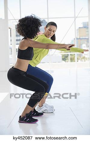 Woman exercising with her instructor in a gym View Large Photo Image Stock Photo - Woman exercising with her instructor in a gym. Fotosearch