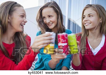 Close-up of three girls toasting with soft drink cans View Large Photo Image Stock Image - Close-up of three girls toasting with soft drink cans. Fotosearch