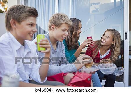 Friends enjoying fast food together View Large Photo Image Stock Photo - Friends enjoying fast food together. Fotosearch
