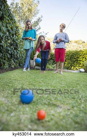 Friends playing Petanque in a garden View Large Photo Image Picture - Friends playing Petanque in a garden. Fotosearch