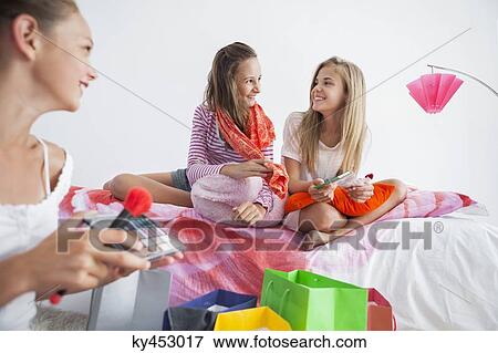 Stock Photo - Girls enjoying good time at a slumber party. Fotosearch