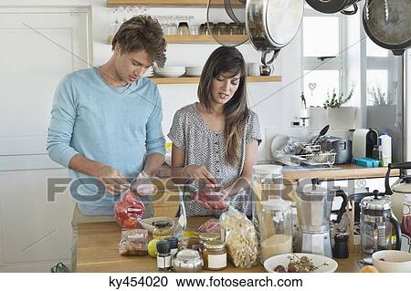 Couple cooking in the kitchen View Large Photo Image Stock Image - Couple cooking in the kitchen. Fotosearch