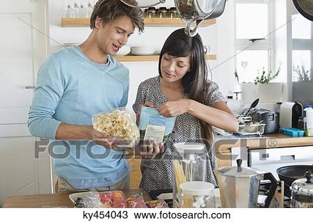 Stock Image - Couple cooking in the kitchen. Fotosearch