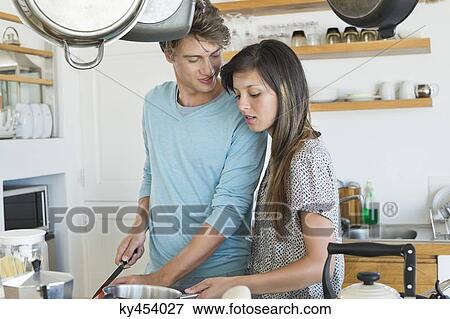 Couple cooking in the kitchen View Large Photo Image Stock Photo - Couple cooking in the kitchen. Fotosearch