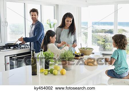 Family preparing food in the kitchen View Large Photo Image Stock Image - Family preparing food in the kitchen. Fotosearch