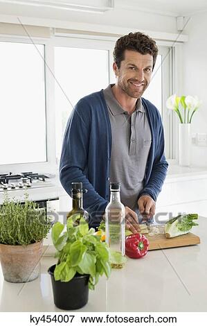 Man chopping vegetables in a kitchen View Large Photo Image Stock Photo - Man chopping vegetables in a kitchen. Fotosearch