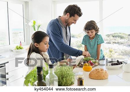 Picture - Man preparing food for his children. Fotosearch