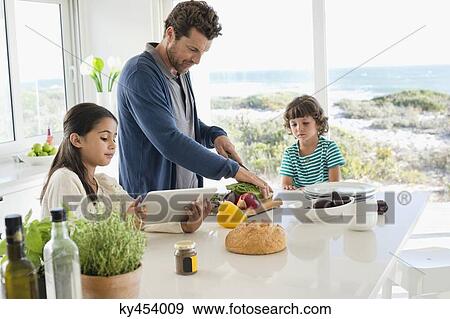 Man preparing food for his children View Large Photo Image Stock Photo - Man preparing food for his children. Fotosearch
