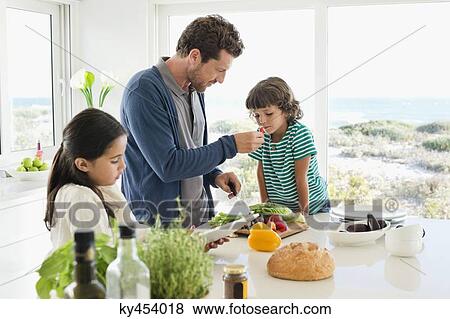 Stock Photo - Man preparing food for his children. Fotosearch