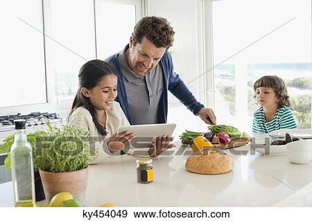 Stock Photo - Man preparing food for his children. Fotosearch