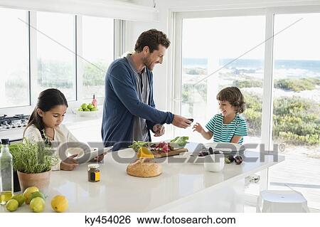 Stock Photograph - Man preparing food for his children. Fotosearch