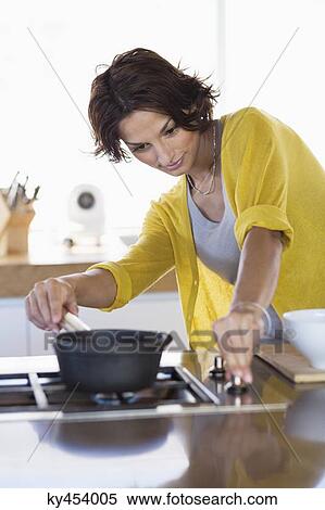 Woman cooking in the kitchen View Large Photo Image Stock Photography - Woman cooking in the kitchen. Fotosearch