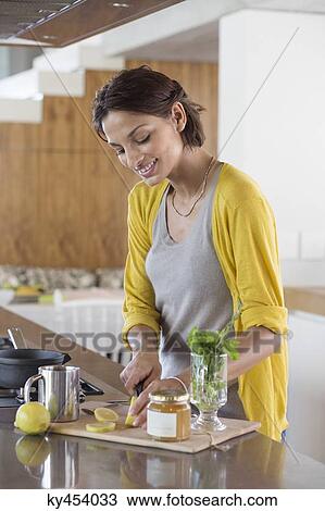 Woman preparing herbal tea in the kitchen View Large Photo Image Stock Image - Woman preparing herbal tea in the kitchen. Fotosearch