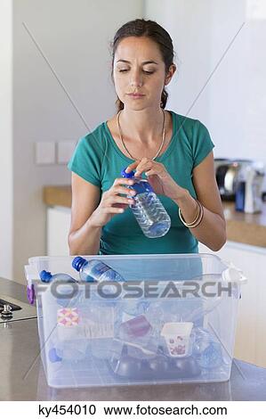 Woman putting a bottle in a recycling bin View Large Photo Image Stock Image - Woman putting a bottle in a recycling bin. Fotosearch