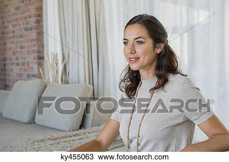 Beautiful woman sitting on a couch and smiling View Large Photo Image Stock Image - Beautiful woman sitting on a couch and smiling. Fotosearch