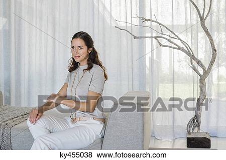 Beautiful woman sitting on a couch View Large Photo Image Stock Photo - Beautiful woman sitting on a couch. Fotosearch