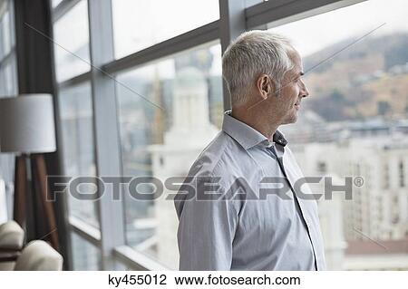 Man looking through a window View Large Photo Image Stock Image - Man looking through a window. Fotosearch