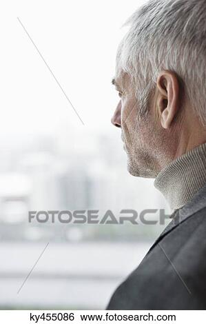 Man looking through a window View Large Photo Image Stock Photograph - Man looking through a window. Fotosearch