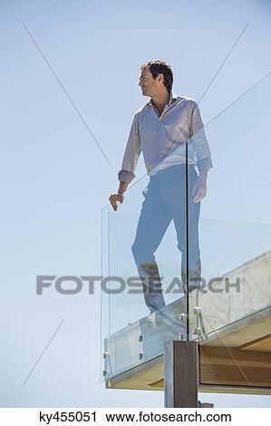 Man standing on the terrace looking away View Large Photo Image Stock Image - Man standing on the terrace looking away. Fotosearch