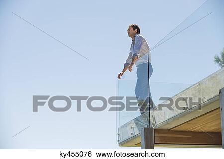 Man standing on the terrace looking away View Large Photo Image Stock Photograph - Man standing on the terrace looking away. Fotosearch
