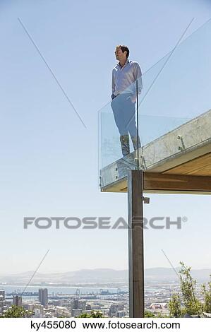 Man standing on the terrace with his hands in his pockets View Large Photo Image Stock Image - Man standing on the terrace with his hands in his pockets. Fotosearch