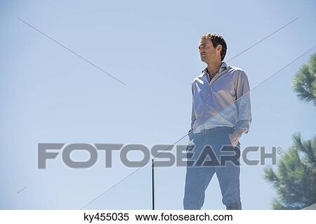 Stock Photography - Man standing on the terrace with his hands in his pockets. Fotosearch