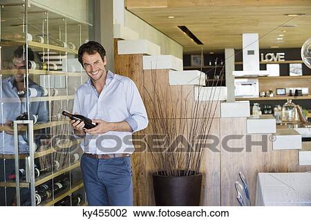 Stock Image - Portrait of a smiling man holding a wine bottle. Fotosearch