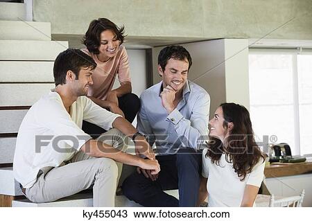 Smiling friends sitting on steps View Large Photo Image Stock Image - Smiling friends sitting on steps. Fotosearch