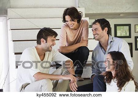 Smiling friends sitting on steps talking to each other View Large Photo Image Stock Image - Smiling friends sitting on steps talking to each other. Fotosearch