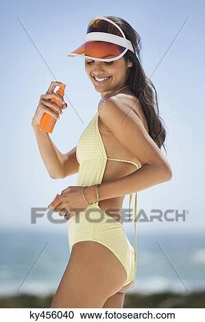 Beautiful woman applying suntan lotion on her shoulder View Large Photo Image Stock Image - Beautiful woman applying suntan lotion on her shoulder. Fotosearch